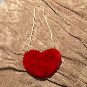 Faux fur pocketbook with faux pearl shoulder strap and pocket zipper.